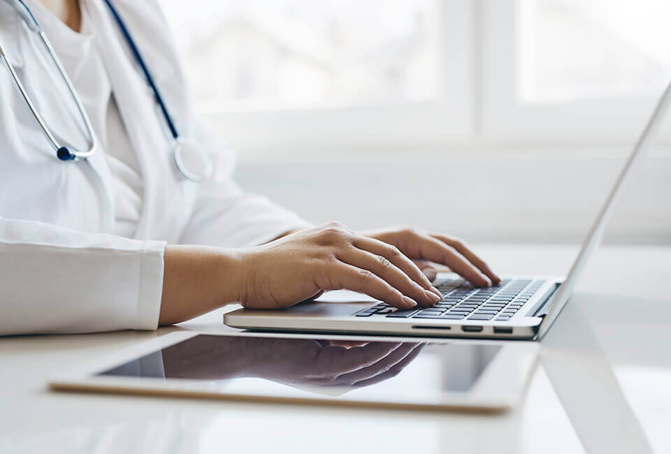 internal medicine doctor typing on his computer